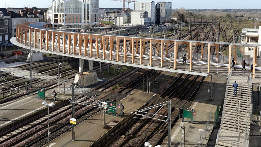 Dietmar Feichtinger Architectes designs gently curving timber bridge over train tracks in Angers