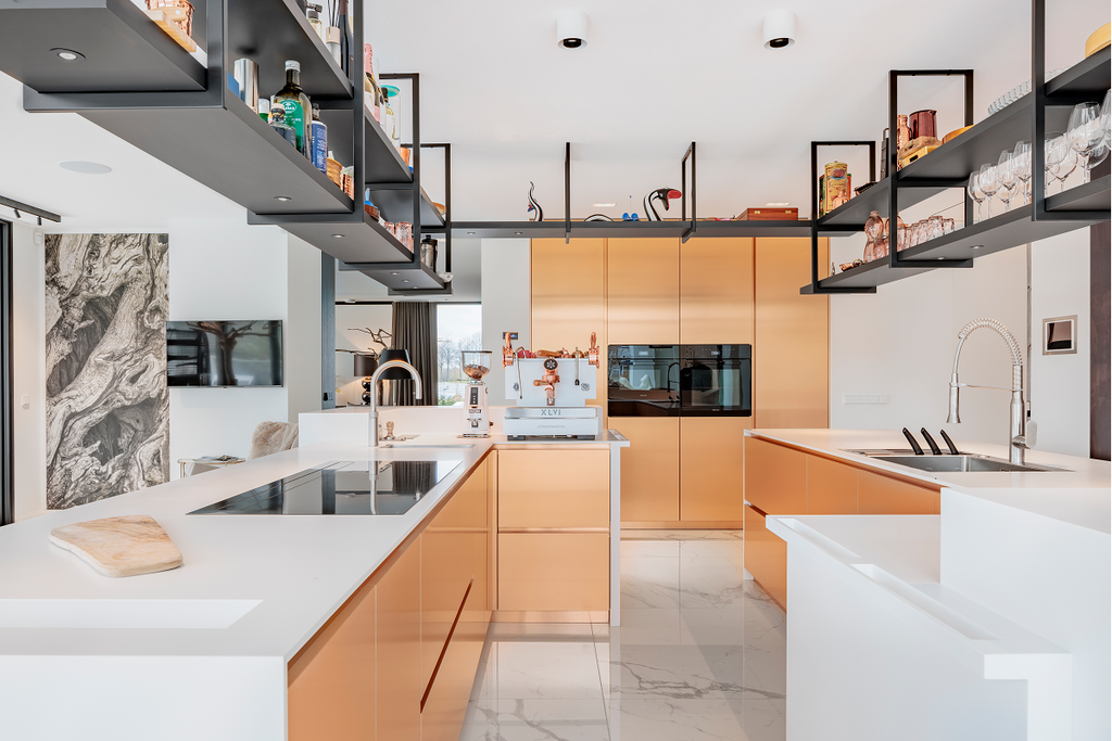 Unos acabados en claro contraste:   HIMACS y el cobre brillan con intensidad en esta cocina