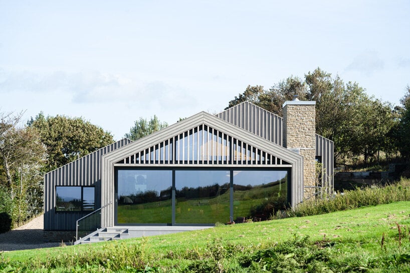 cluster of pitched timber volumes by coffey architects perch above dorset's sloping hillside