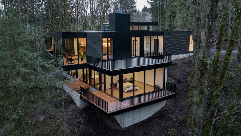 Black wood and glass volumes stagger down Oregon woodland to form Royal house